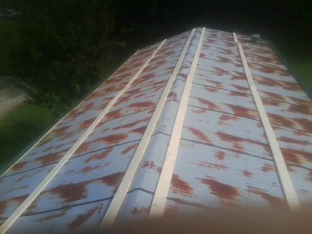 Rusted metal roof panels with new wood purlins before replacement — Storm Damage Roof Repair in Vernon Center by Roofing Brothers
