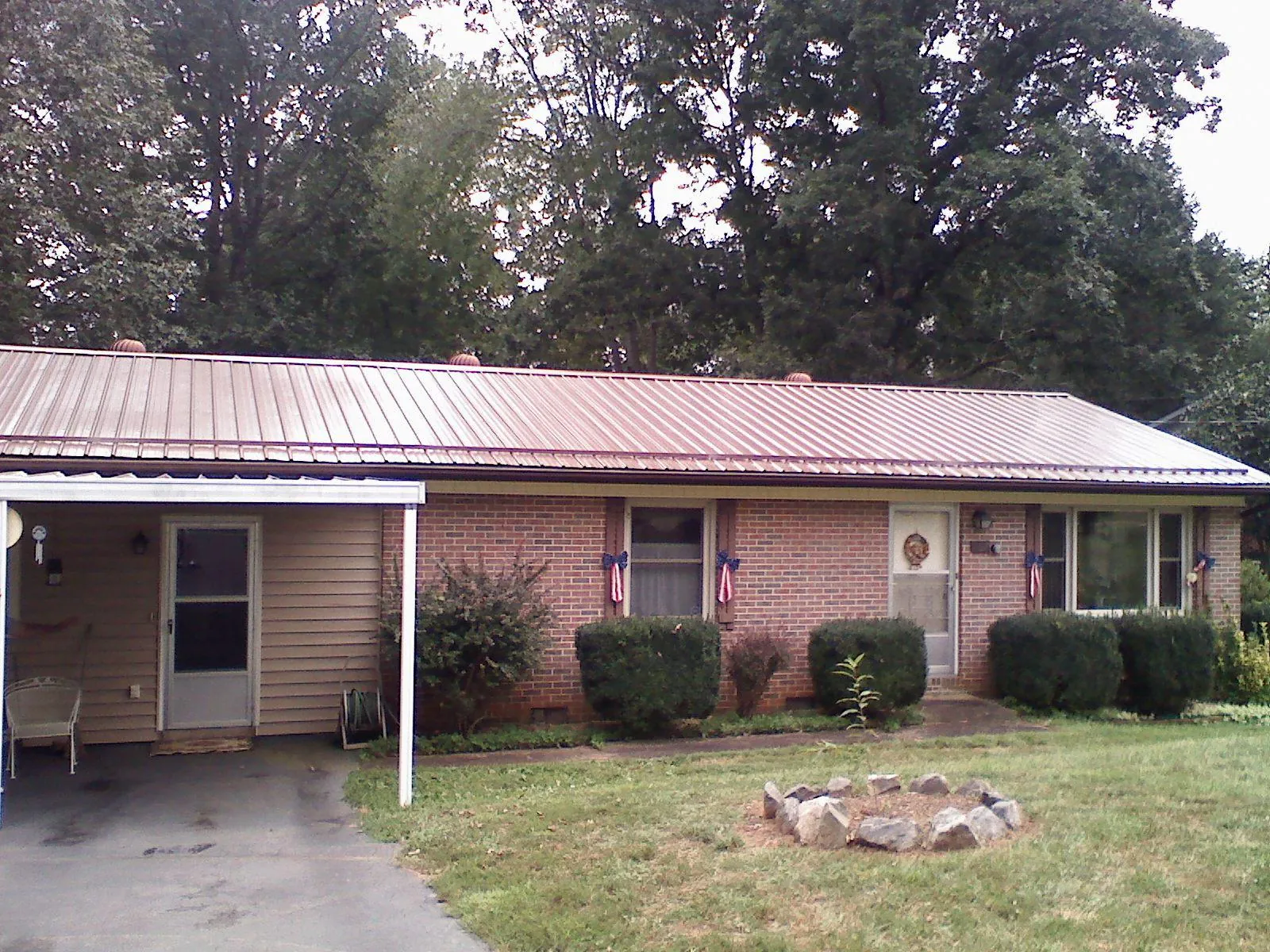 Bronze metal roof and carport on a brick ranch home — Roof Repair work by our crew in Vernon Center